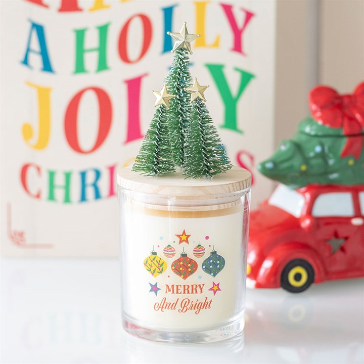 شمعة زجاجية برائحة القرفة والتوابل من مجموعة "Merry and Bright" مع زينة شجرة